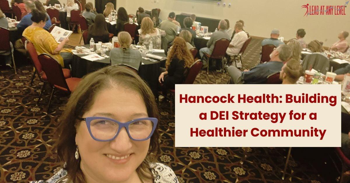 Amy Waninger poses for a selfie with leaders from Hancock Health seated at tables in the background